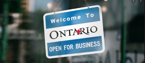 blue and white sign welcome to Ontario open for business