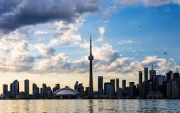 photo from the water looking at Toronto's waterfront with CN tower and Roger's centre