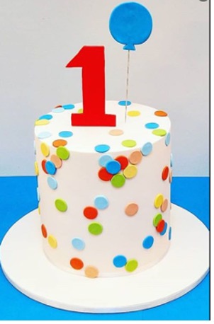 birthday cake with colourful dots on it and a red #1 on top