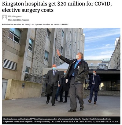 men wearing masks walking past a hospital building