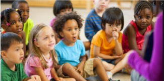 a group of young children sitting on a classroom floor