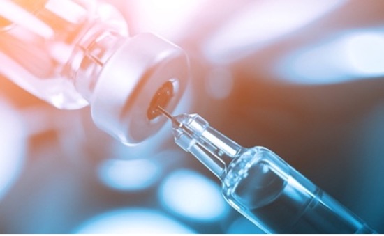 syringe with needle drawing vaccine from bottle