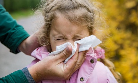 picture of an adult blowing a Childs nose