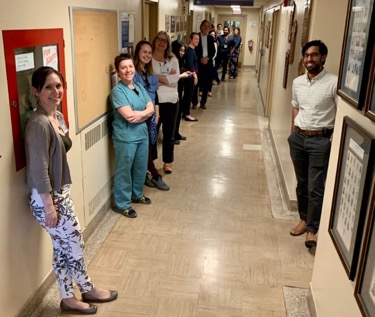 DOM staff in hallway lined up for food