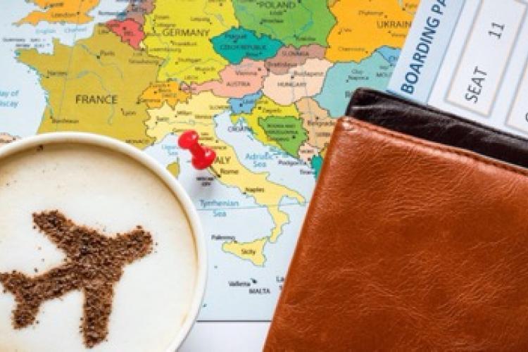 map, boarding pass, latte with cinnamon image of plane and passport holder