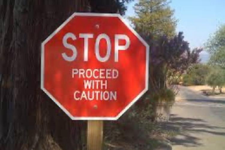 stop sign with proceed with caution on it